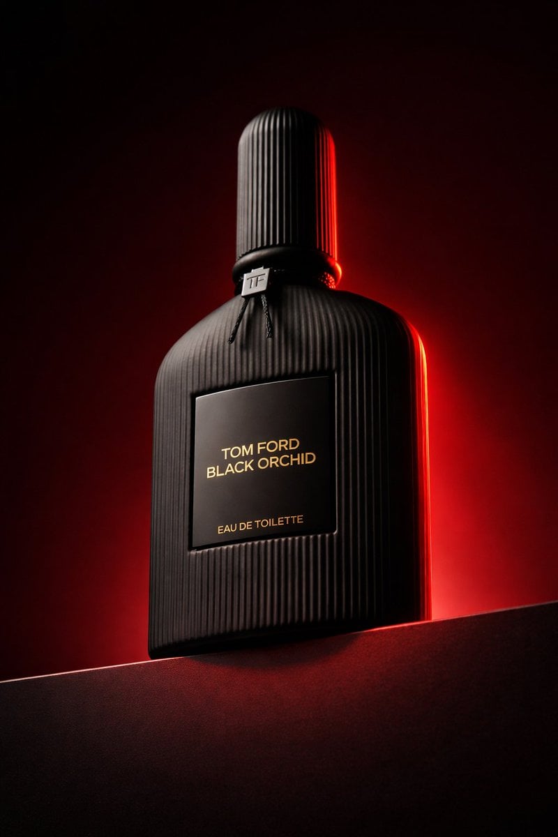 Low angle luxury product photography of a black ribbed glass perfume bottle plac