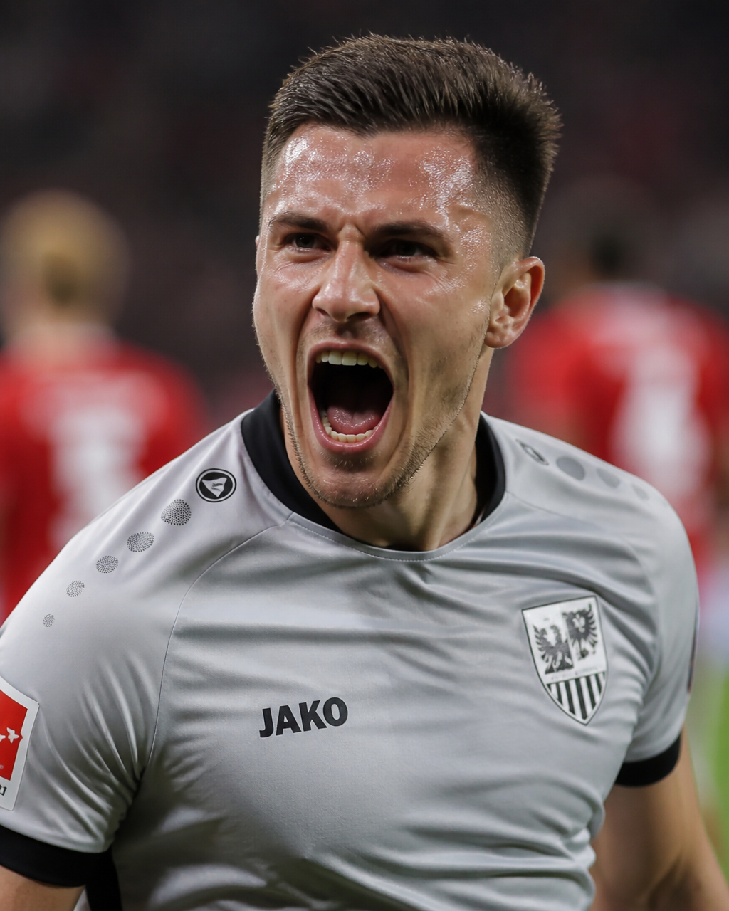 A professional soccer player celebrates a goal with an intense, wide-mouthed exp